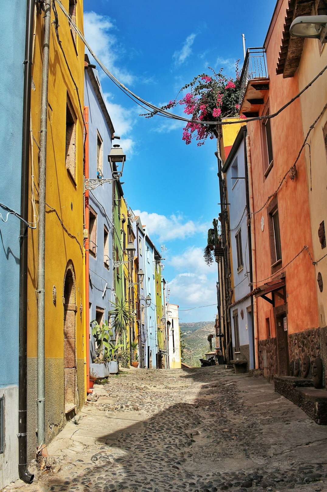 Calle empinada con casas de colores y cables eléctricos en un cerro chileno